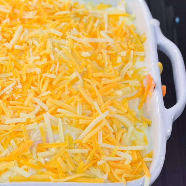 Top the final layer of white sauce with the shredded cheddar cheese. 
