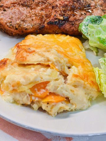 This cheese scalloped potatoes recipe uses both yellow potatoes and sweet potatoes along with onions, white sauce, and lots of cheese to make the ultimate cheesy au gratin potatoes.