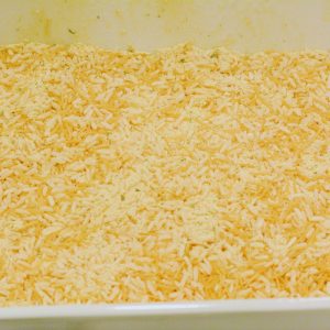 Begin by spraying a casserole dish or 13x9 pan with cooking spray and pouring the packaged rice mixes into the baking dish.