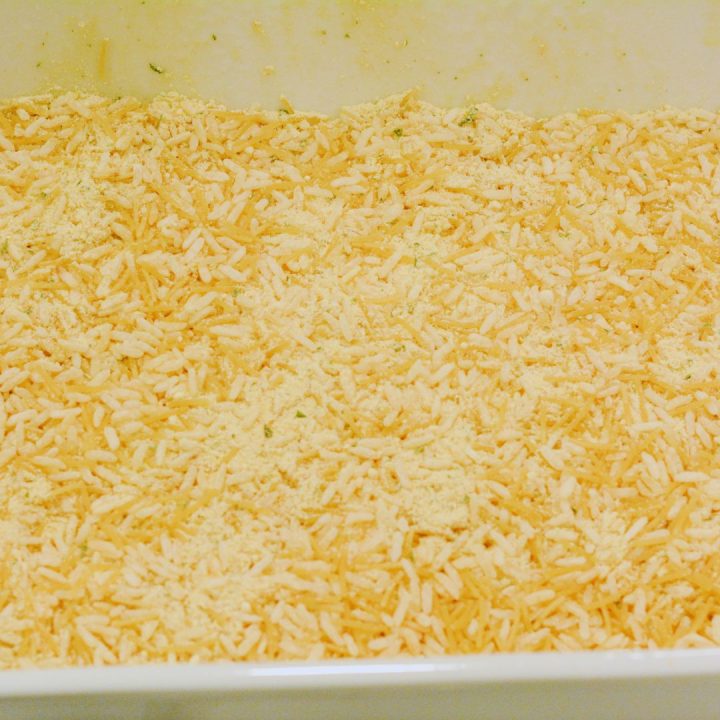 Begin by spraying a casserole dish or 13x9 pan with cooking spray and pouring the packaged rice mixes into the baking dish.