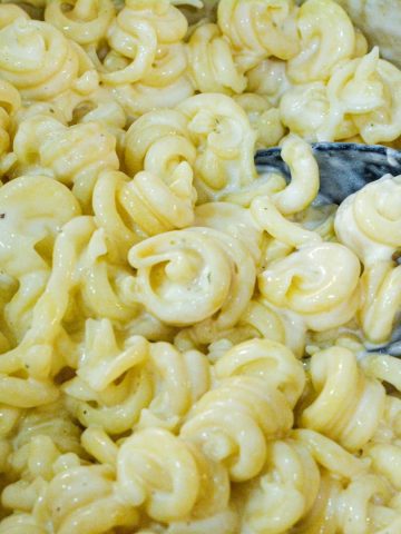 Add milk a quarter cup at a time until the consistency you like. Serve the white macaroni and cheese immediately after all cheese is melted.