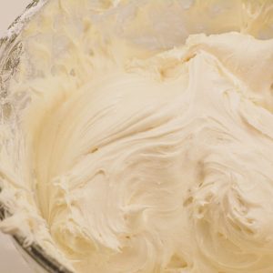 Slowly add the powdered sugar to the cream cheese mixture until the cream cheese icing reaches the desired thickness or consistency.