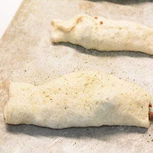 Wrap the hamburger meat and cheese in the dough. The seam for the dough can be on the top or the bottom. Sprinkle garlic salt over the top of each taco stick.