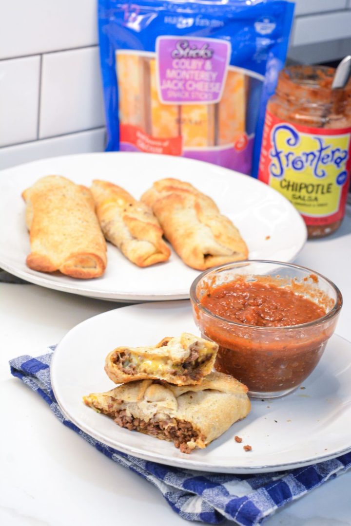 Taco sticks are made by wrapping taco meat and a colby-jack cheese stick in pizza dough then baking for 10 minutes for an easy weeknight meal recipe.