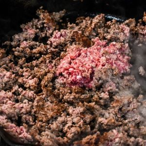 Brown the ground beef in a skillet.