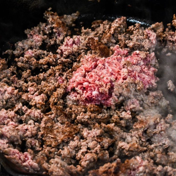 Brown the ground beef in a skillet. Then stir in the taco seasoning and water and cook down the water. 
