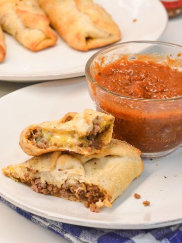 Taco sticks are made by wrapping taco meat and a colby-jack cheese stick in pizza dough then baking for 10 minutes for an easy weeknight meal recipe.