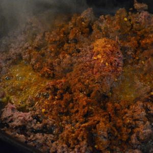 When beef is cooked, add taco seasoning and water. Stir to combine.