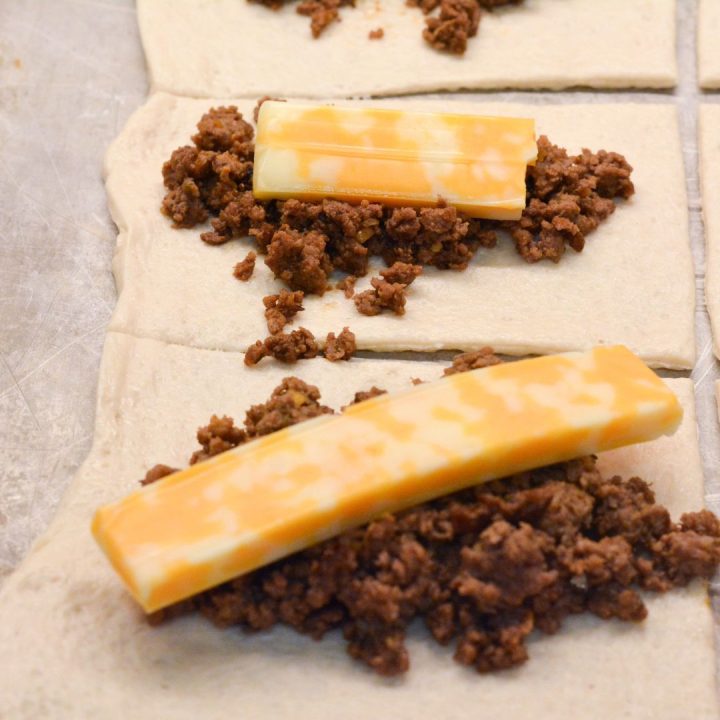 Spoon the taco meat on the rectangles and then top with a cheese stick.