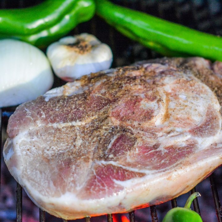 Start making this flavorful and smoky chile verde by doing a short smoke on the pork shoulder. Cover with oil and season with adobo seasoning. 