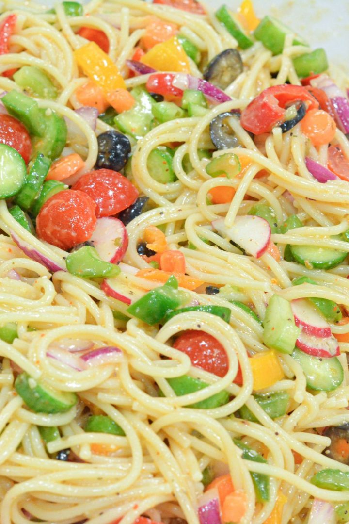 Cold Spaghetti Pasta Salad is a garden vegetable heaven in this delicious Italian pasta salad filled with cucumbers, celery, carrots, onions, peppers, olives, tomatoes, and parmesan cheese.