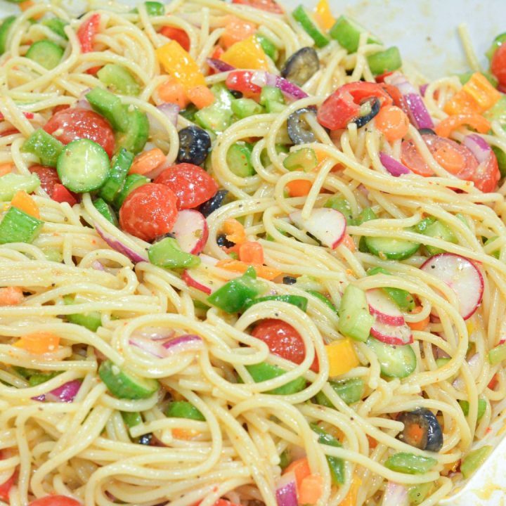 Cold Spaghetti Pasta Salad is a garden vegetable heaven in this delicious Italian pasta salad filled with cucumbers, celery, carrots, onions, peppers, olives, tomatoes, and parmesan cheese.