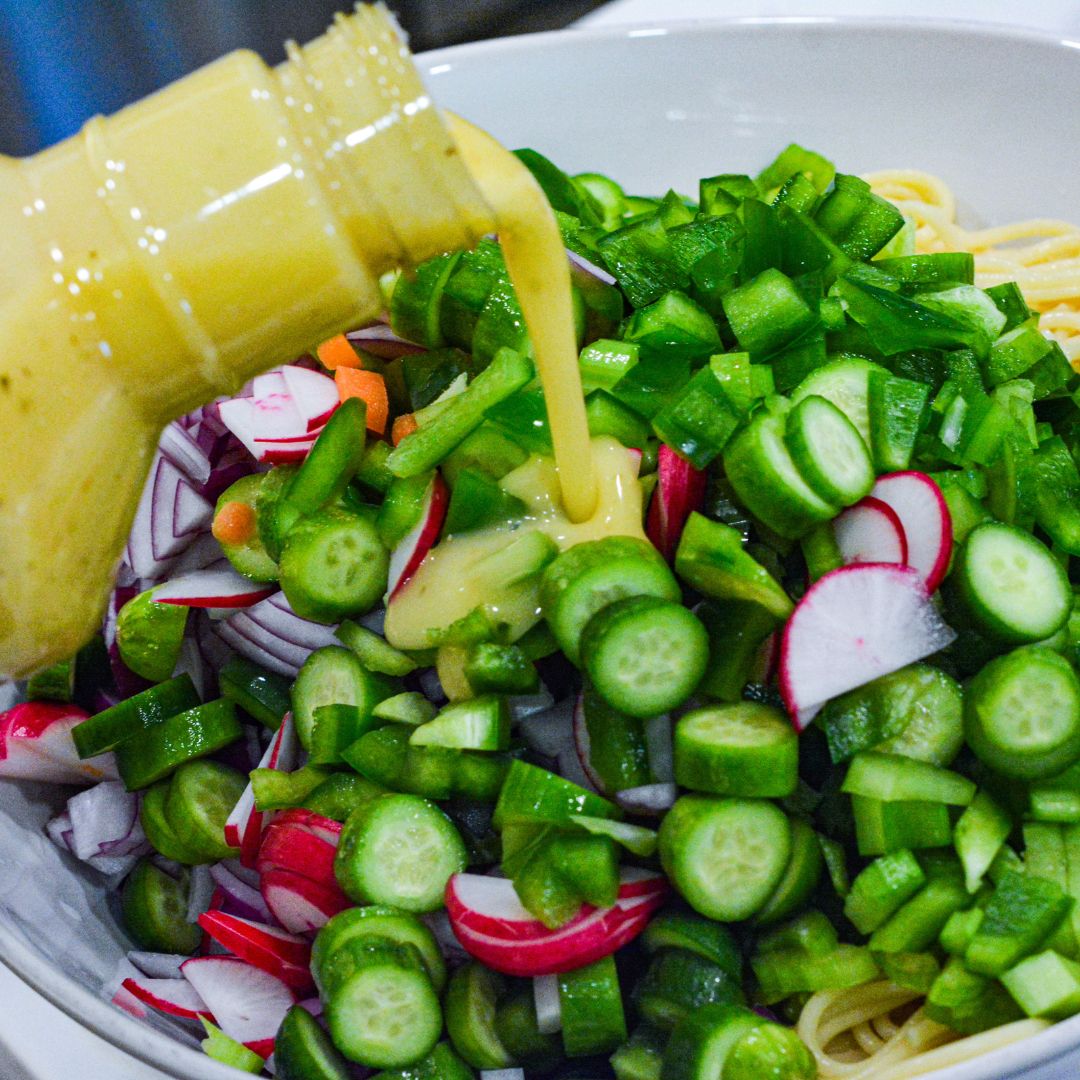 In a large mixing bowl, combine the cooled spaghetti,  cucumber, red bell pepper, and red onion. Pour the Italian dressing over the vegetables.