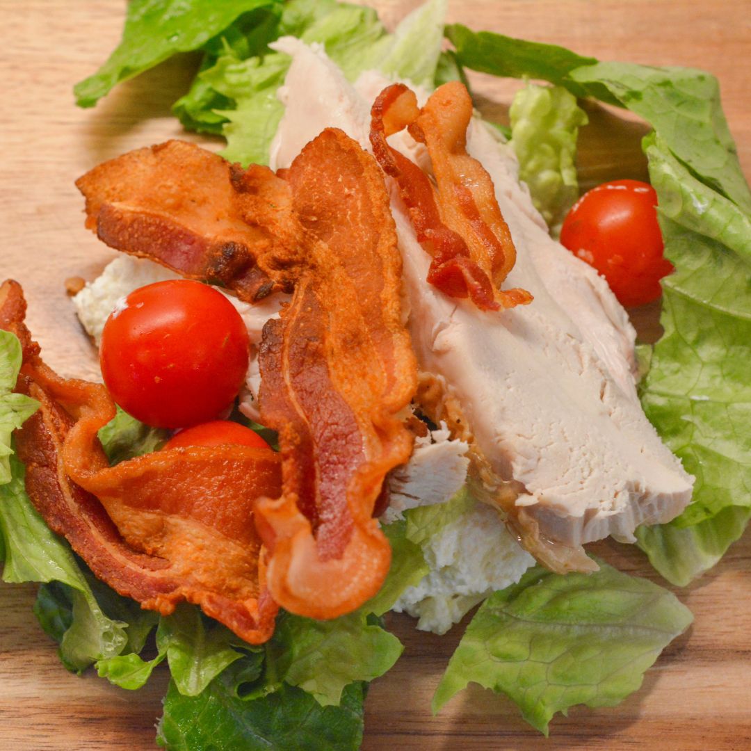 On a large cutting board, pile the chicken, bacon, lettuce, and tomatoes together. Use a sharp knife or mezzaluna to finely chop everything into small, bite-sized pieces.