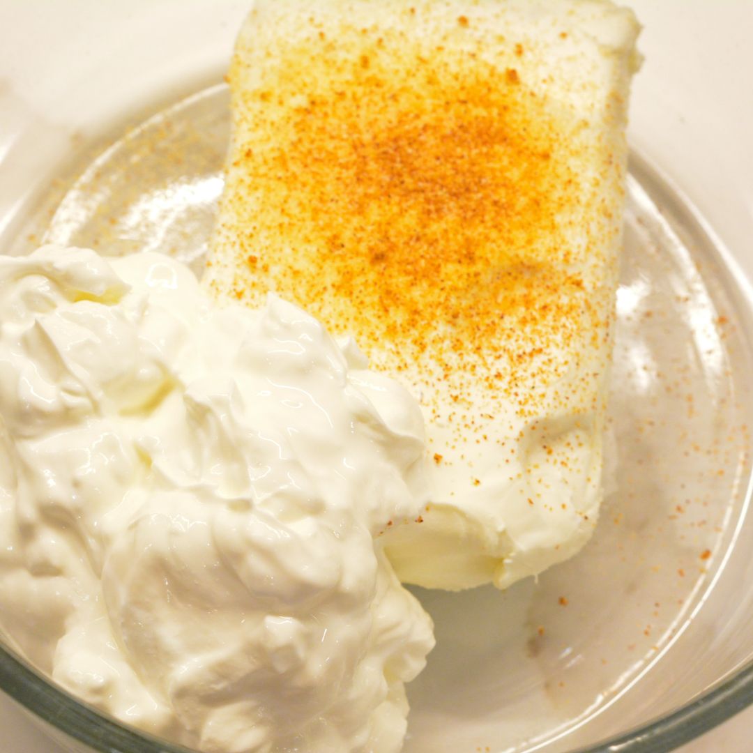 In a large bowl, mix the softened cream cheese and sour cream along with the onion and garlic powder until smooth and fluffy. You can use a hand mixer to make this easier.