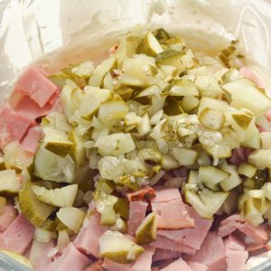 Add in the chopped pickles, deli ham, and dill. Mix well until everything is evenly coated in the creamy base.