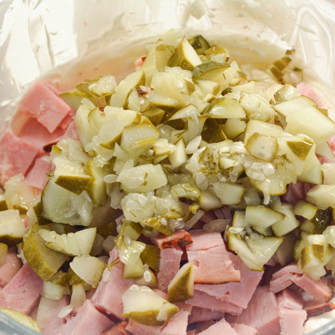 Add in the chopped pickles, deli ham, and dill. Mix well until everything is evenly coated in the creamy base.