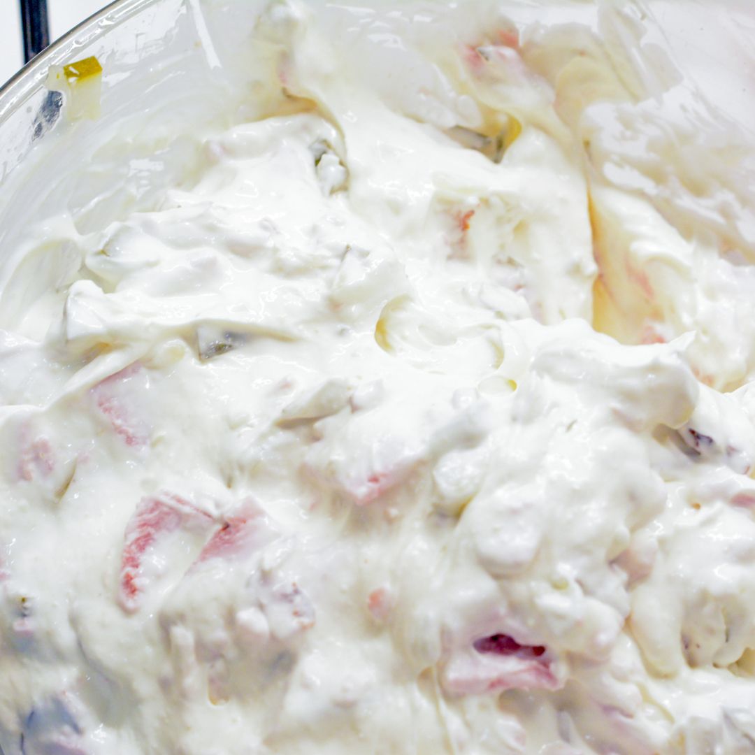 Add in the chopped pickles, deli ham, and dill. Mix well until everything is evenly coated in the creamy base.