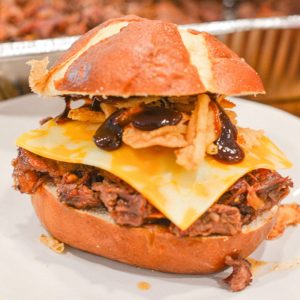 Load shredded beef onto each bun. Top with Colby Jack cheese, crispy bacon, fried onions, and pickles. Serve hot with extra barbecue sauce on the side.