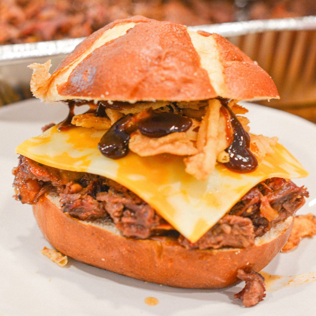 Load shredded beef onto each bun.
Top with Colby Jack cheese, crispy bacon, fried onions, and pickles.
Serve hot with extra barbecue sauce on the side.