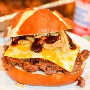 Make hearty Smoked Cowboy Beef Sandwiches with tender chuck roast, barbecue seasoning, and a rich sauce—smoked or slow-cooked in the crock pot, then piled high with cheese, bacon, fried onions, and pickles.