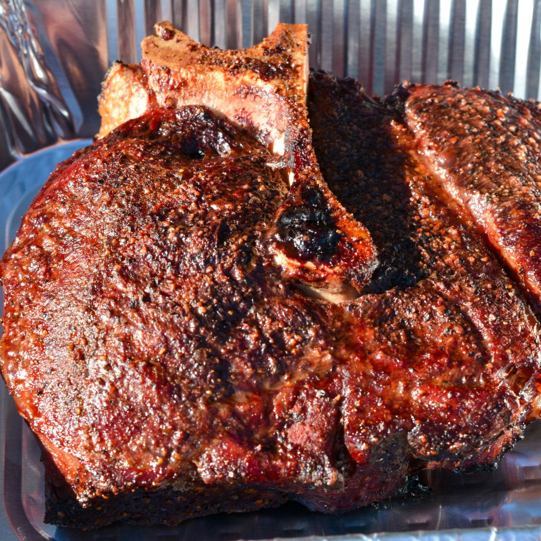 In a large Dutch oven or foil pan, combine barbecue sauce, beef broth, Coca-Cola, Worcestershire sauce, sliced onion, garlic, jalapeños, and bacon.