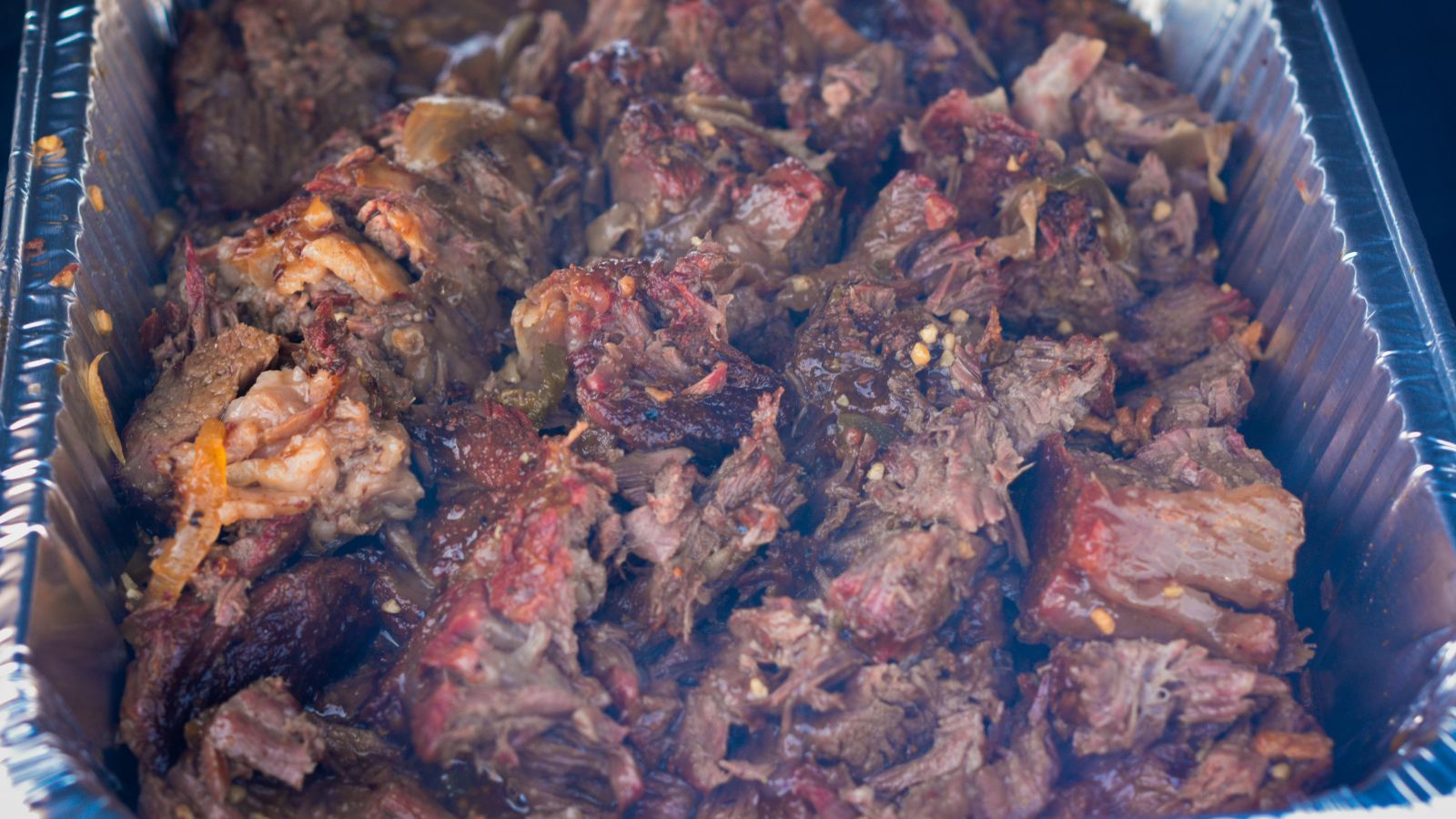 Return the shredded beef to the braising liquid, cover in barbecue sauce, and stir to coat.