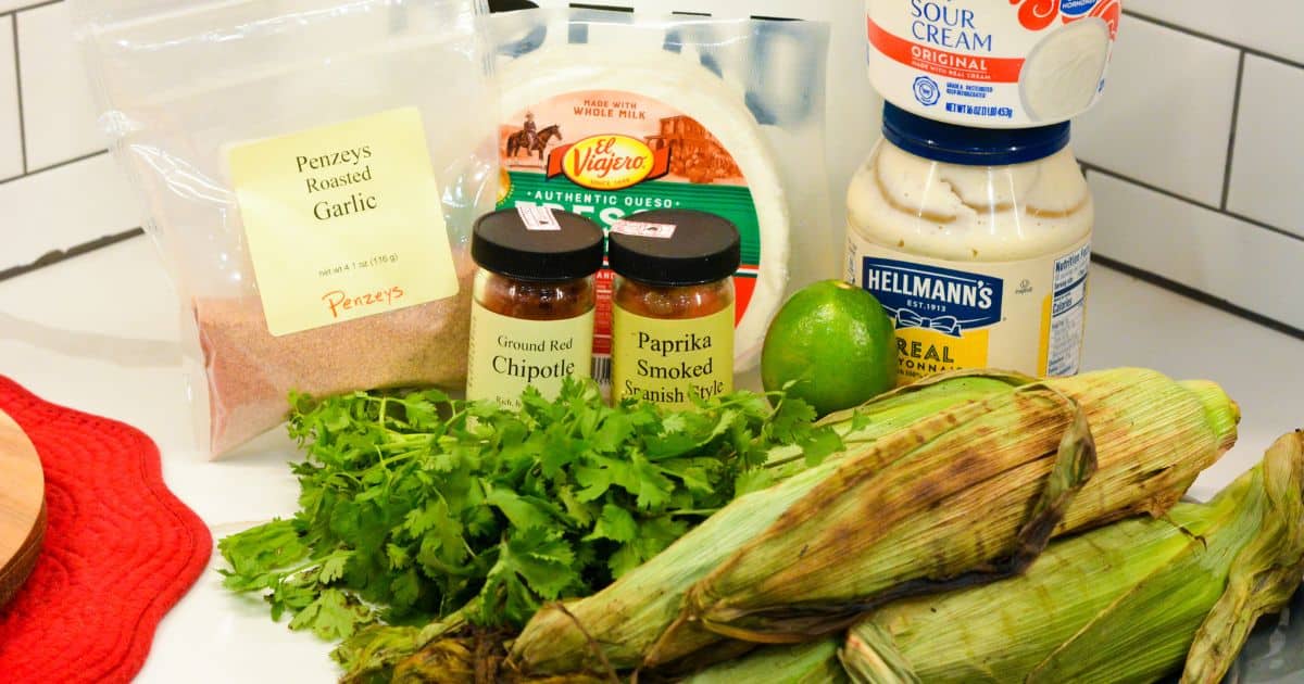 Ingredients for Mexican street corn salad including queso fresco, mayonnaise, sour cream, chipotle, and smoked paprika